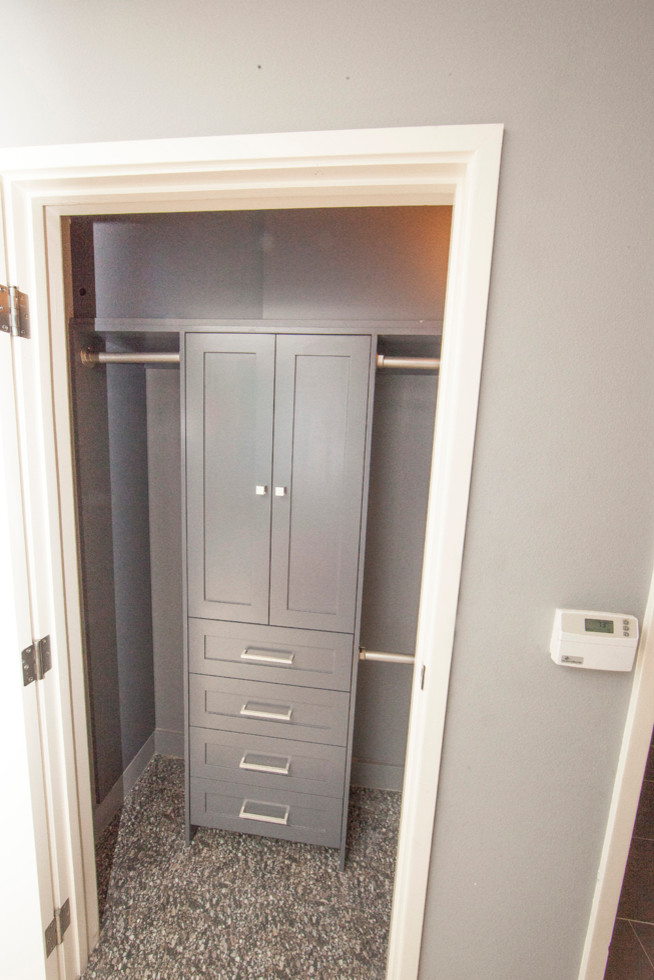 Design ideas for a small contemporary men's built-in wardrobe in Los Angeles with shaker cabinets, grey cabinets, cork floors and grey floor.