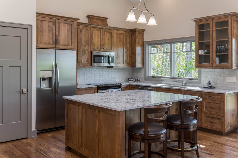 Inspiration for a mid-sized transitional l-shaped dark wood floor and brown floor enclosed kitchen remodel with an undermount sink, recessed-panel cabinets, dark wood cabinets, granite countertops, white backsplash, stone tile backsplash, stainless steel appliances, an island and gray countertops