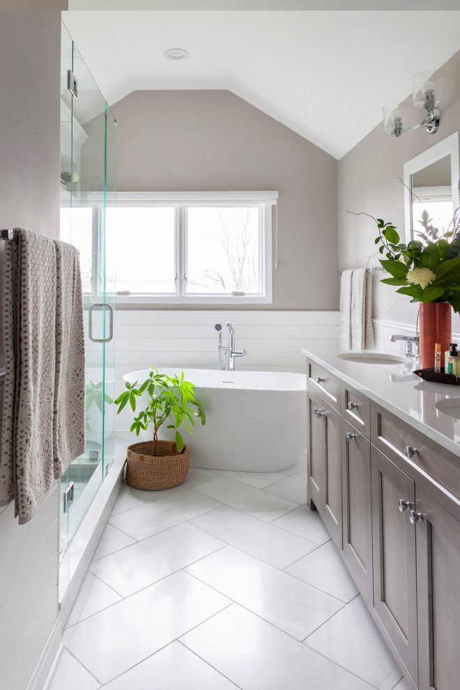 Inspiration for a mid-sized transitional bathroom in Chicago with shaker cabinets, medium wood cabinets, a freestanding tub, white tile, subway tile, grey walls, an undermount sink, white floor, white benchtops, a double vanity, a freestanding vanity and vaulted.