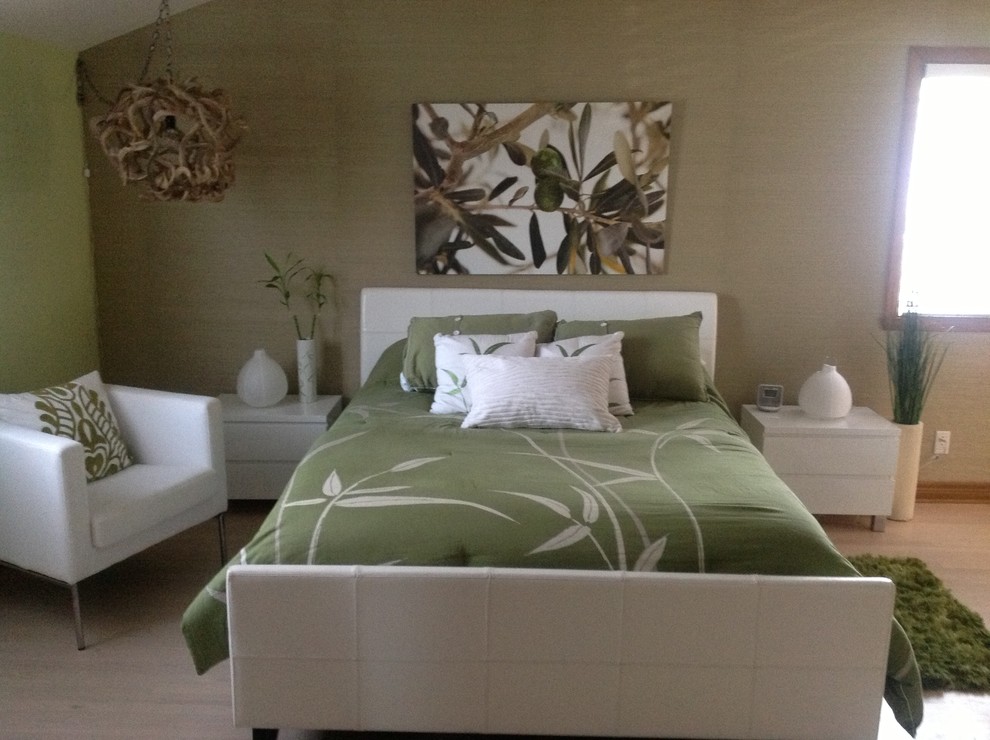 This is an example of a large contemporary bedroom in Montreal with green walls, light hardwood floors and no fireplace.