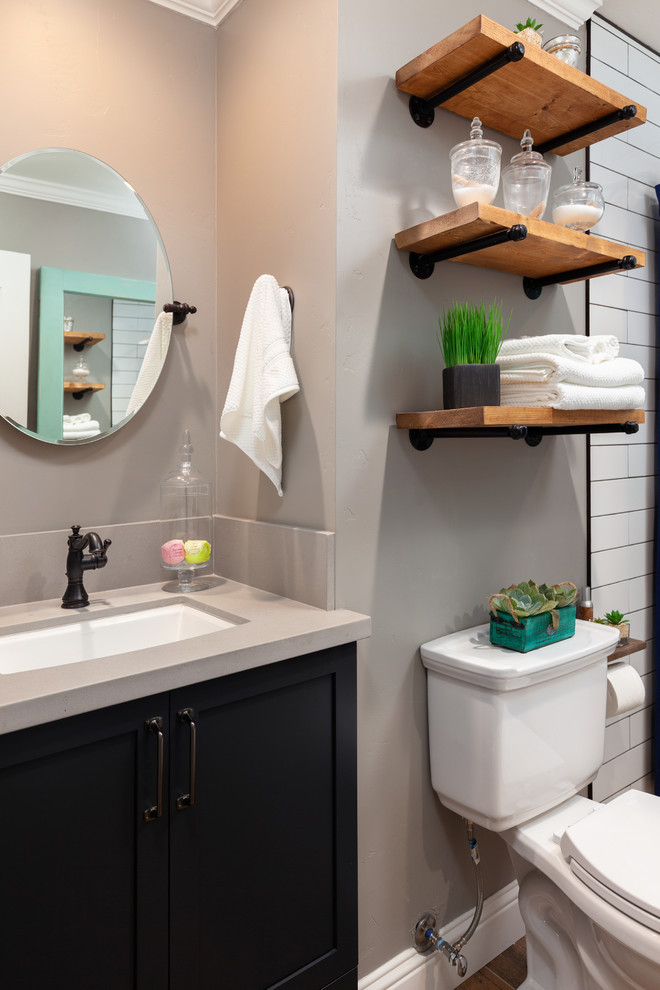 This is an example of a mid-sized industrial master bathroom in Other with raised-panel cabinets, brown cabinets, a freestanding tub, a shower/bathtub combo, a two-piece toilet, white tile, porcelain tile, beige walls, an undermount sink, wood benchtops, brown floor, a shower curtain, beige benchtops and porcelain floors.