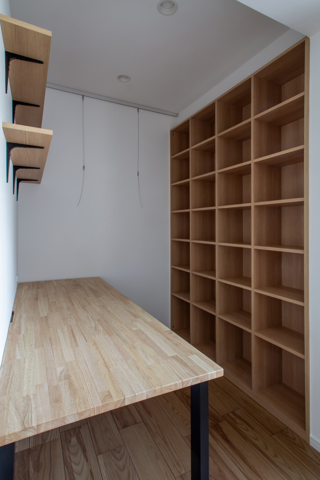 Diseño de despacho blanco escandinavo de tamaño medio sin chimenea con paredes púrpuras, suelo de madera en tonos medios, escritorio empotrado, suelo beige, papel pintado y papel pintado