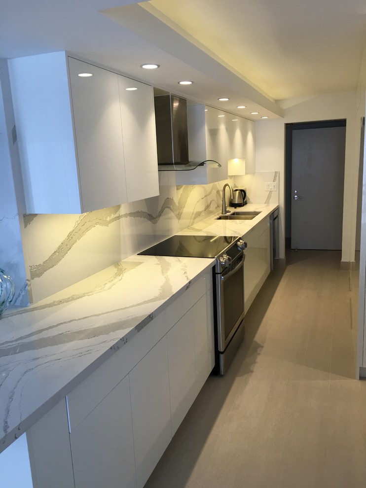 Inspiration for a mid-sized contemporary l-shaped eat-in kitchen in Miami with a double-bowl sink, flat-panel cabinets, white cabinets, quartz benchtops, white splashback, stainless steel appliances, porcelain floors, a peninsula and beige floor.