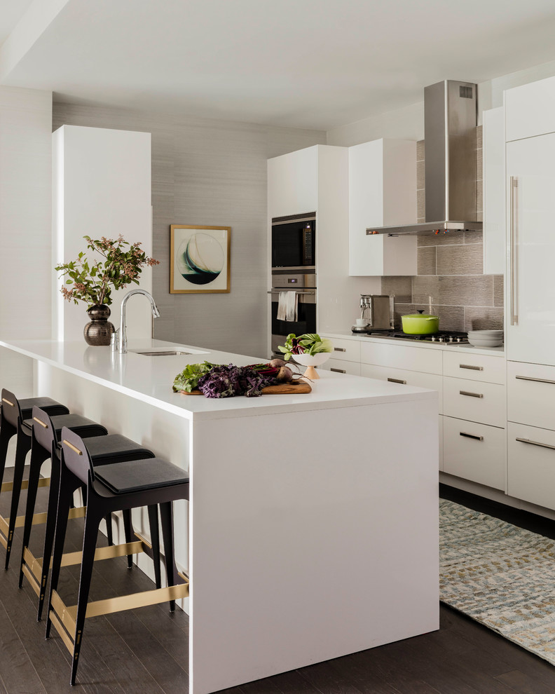 Design ideas for a mid-sized contemporary galley kitchen in Boston with an undermount sink, flat-panel cabinets, white cabinets, quartz benchtops, stainless steel appliances, dark hardwood floors, a peninsula, brown floor, white benchtop and grey splashback.
