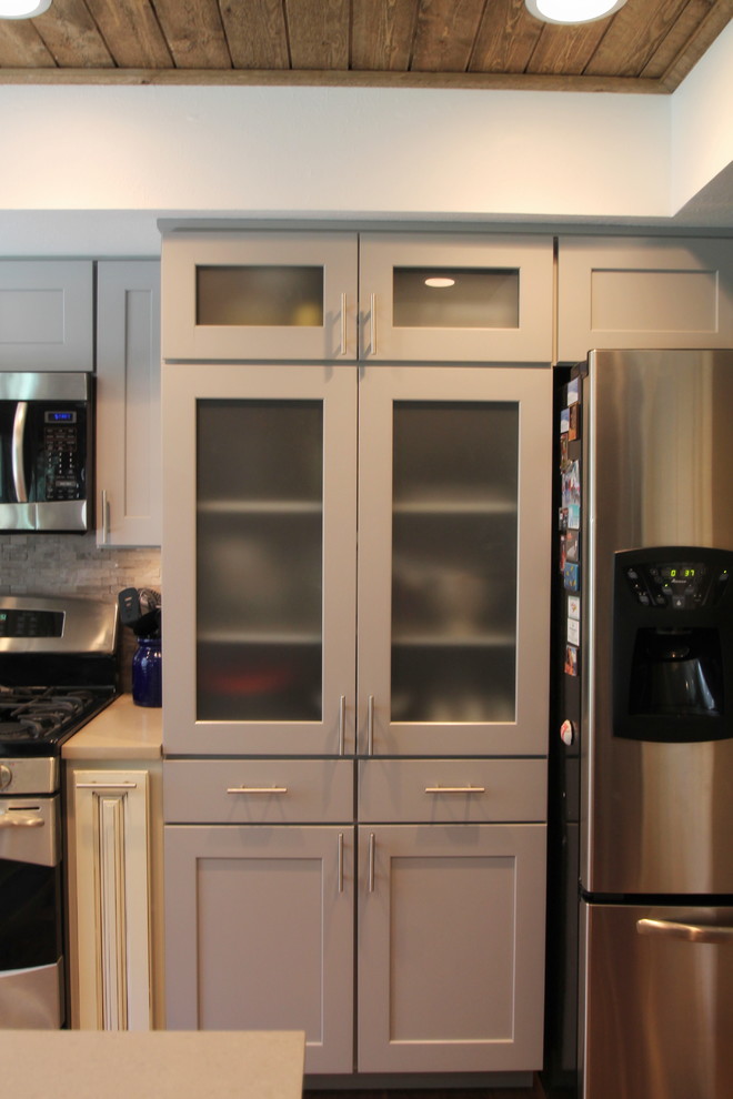 Large transitional l-shaped medium tone wood floor eat-in kitchen photo in Denver with an undermount sink, shaker cabinets, gray cabinets, quartz countertops, gray backsplash, stone tile backsplash, stainless steel appliances and an island