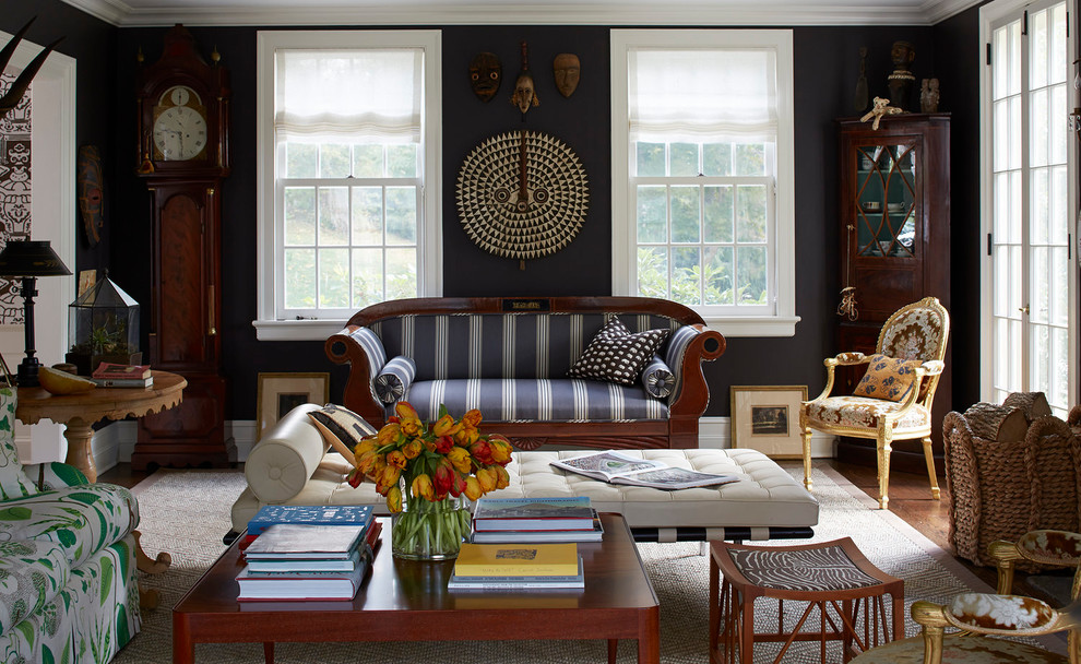 Photo of an eclectic enclosed living room in New York with black walls and dark hardwood floors.
