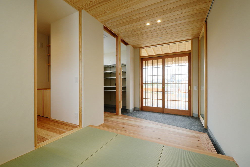 Inspiration pour une grande entrée avec un couloir, un mur blanc, un sol de tatami, une porte coulissante, une porte en bois brun, un sol vert, un plafond en bois et du papier peint.