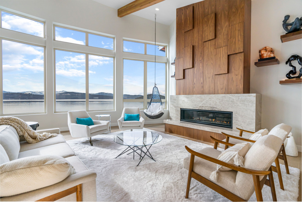 Offenes Modernes Wohnzimmer mit weißer Wandfarbe, braunem Holzboden, Gaskamin, Kaminumrandung aus Stein, braunem Boden und freigelegten Dachbalken in Seattle