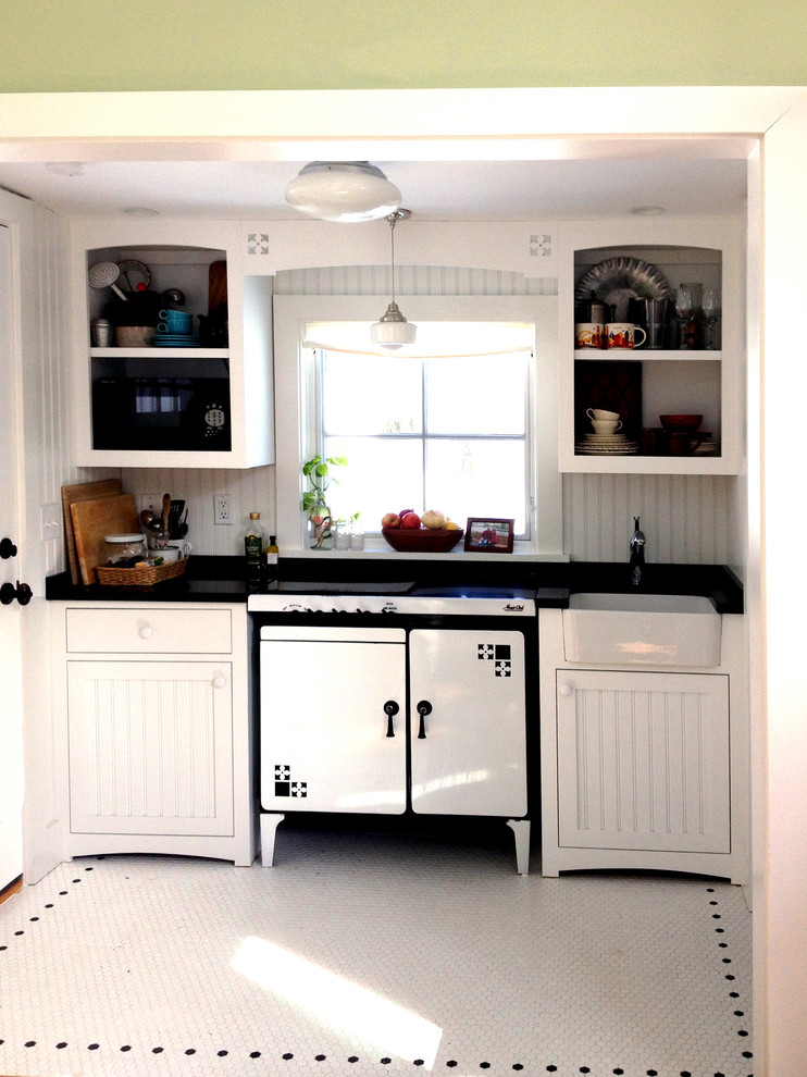 Inspiration for a small country single-wall separate kitchen in Bridgeport with a farmhouse sink, beaded inset cabinets, white cabinets, granite benchtops, black splashback, stone slab splashback, white appliances, ceramic floors, no island and white floor.