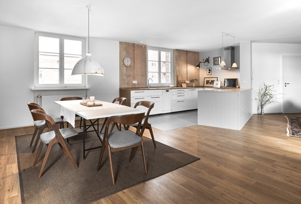 Design ideas for an expansive contemporary kitchen/dining combo in Hamburg with white walls, medium hardwood floors, brown floor and no fireplace.