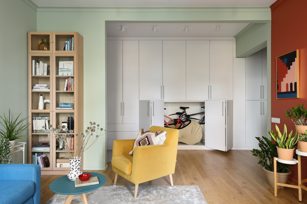 Свежая идея для дизайна: гостиная комната среднего размера в скандинавском стиле с разноцветными стенами, паркетным полом среднего тона, коричневым полом и синим диваном без телевизора - отличное фото интерьера