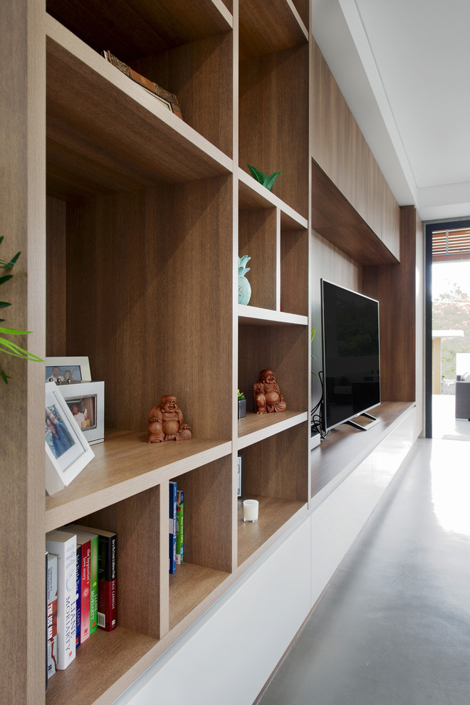 This is an example of a mid-sized contemporary family room in Brisbane with concrete floors, a built-in media wall and grey floor.