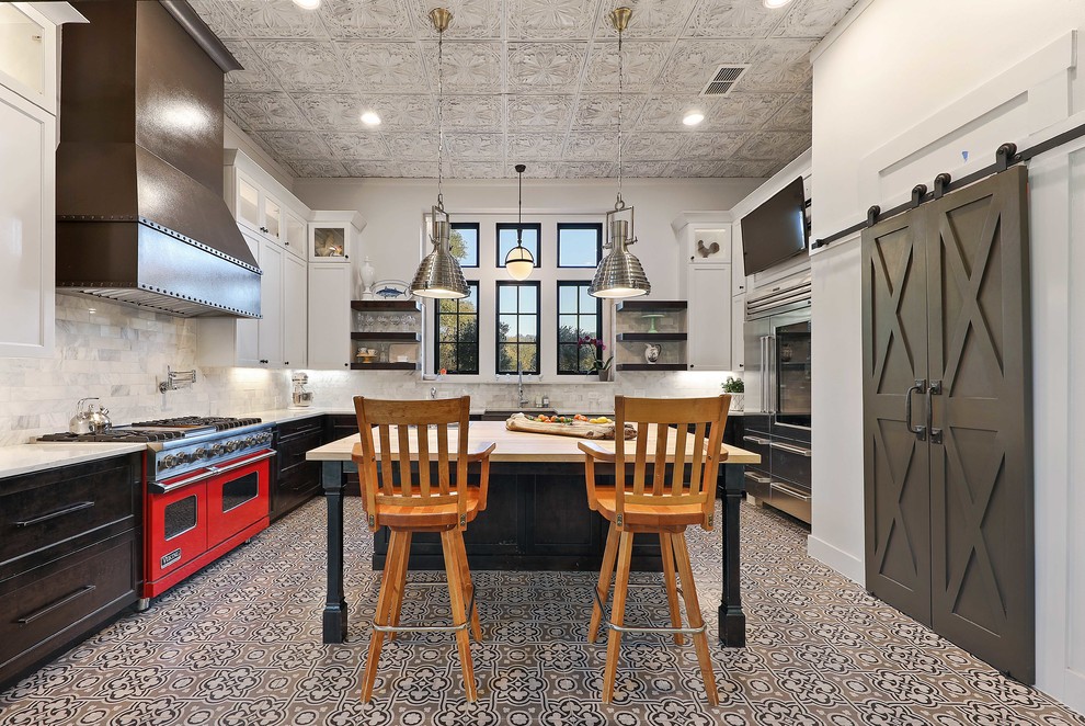 Inspiration for a country u-shaped kitchen in Austin with shaker cabinets, black cabinets, white splashback, stainless steel appliances, cement tiles, with island, multi-coloured floor and white benchtop.