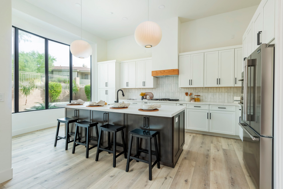 Design ideas for a large transitional eat-in kitchen in Phoenix with a single-bowl sink, shaker cabinets, dark wood cabinets, quartz benchtops, white splashback, subway tile splashback, stainless steel appliances, vinyl floors, with island, brown floor and white benchtop.
