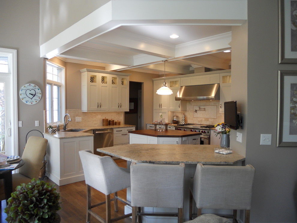 Inspiration for a large transitional u-shaped medium tone wood floor eat-in kitchen remodel in New York with an undermount sink, recessed-panel cabinets, white cabinets, granite countertops, multicolored backsplash, porcelain backsplash, stainless steel appliances, gray walls and an island