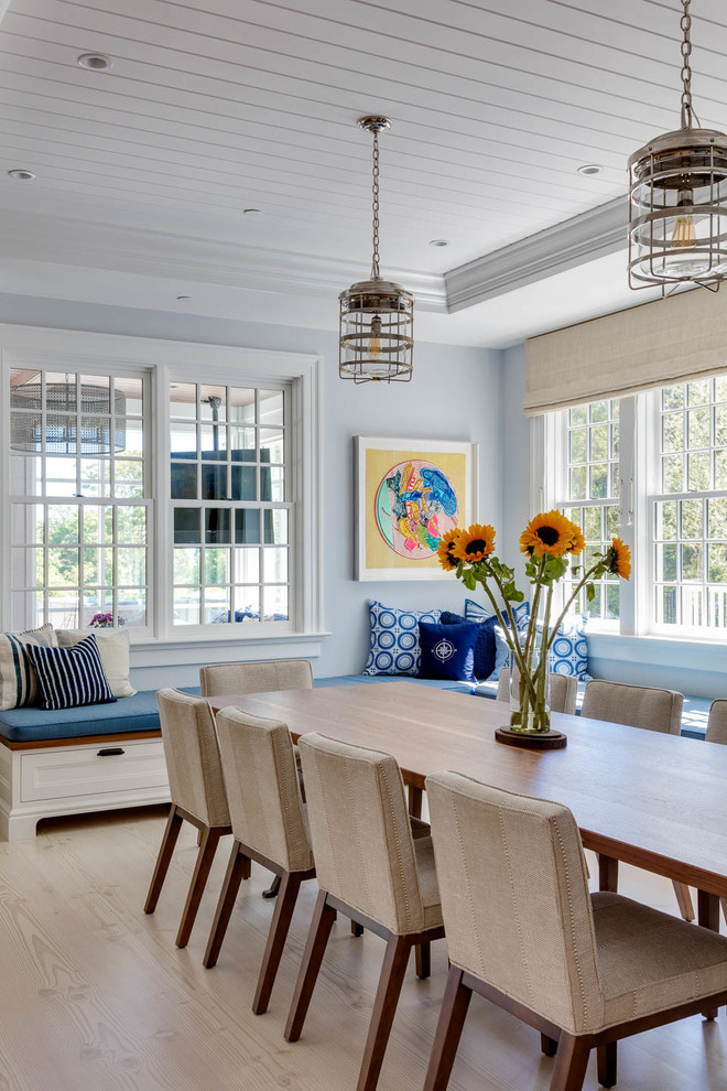 This is an example of a beach style dining room in Boston with blue walls, light hardwood floors and beige floor.