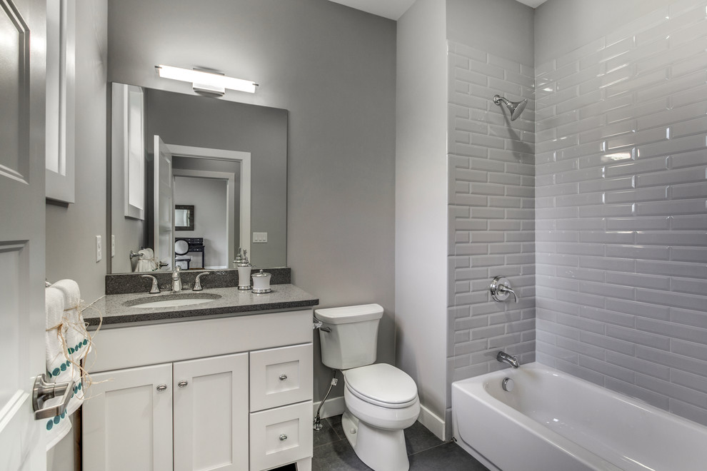 Mid-sized transitional white tile and subway tile porcelain tile and gray floor alcove bathtub photo in Boston with shaker cabinets, white cabinets, a two-piece toilet, gray walls and an undermount sink