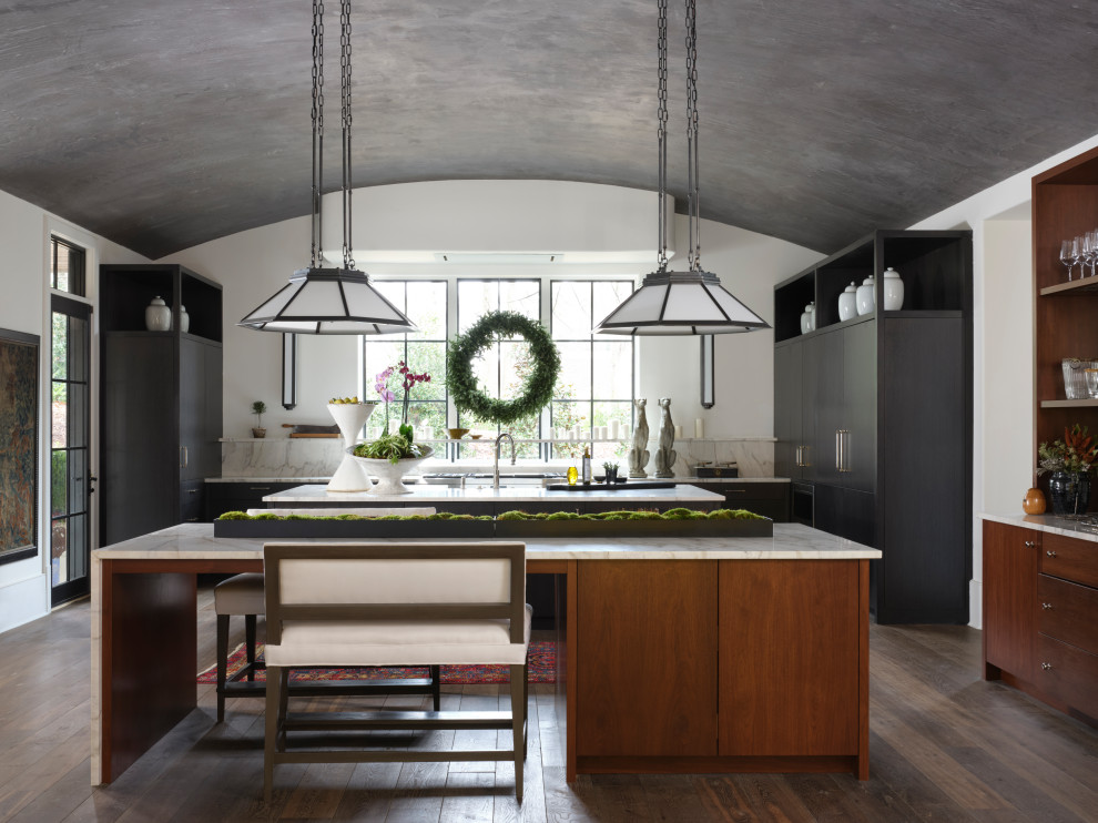 This is an example of a contemporary u-shaped kitchen in Atlanta with flat-panel cabinets, black cabinets, white splashback, dark hardwood flooring, multiple islands, brown floors, white worktops and a vaulted ceiling.