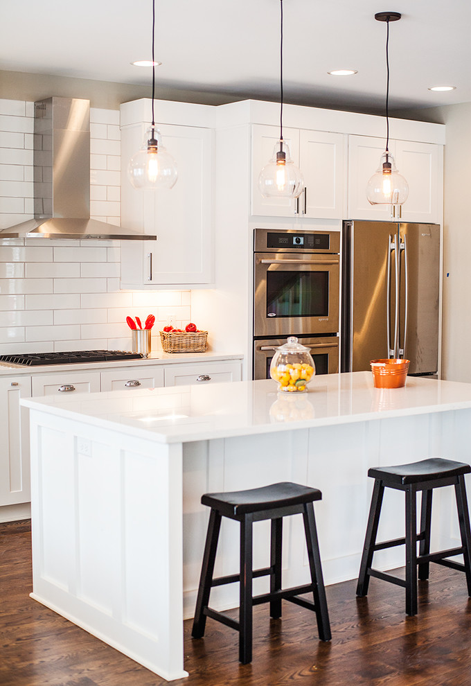 Inspiration for a transitional kitchen in Minneapolis with white cabinets, white splashback, subway tile splashback and with island.