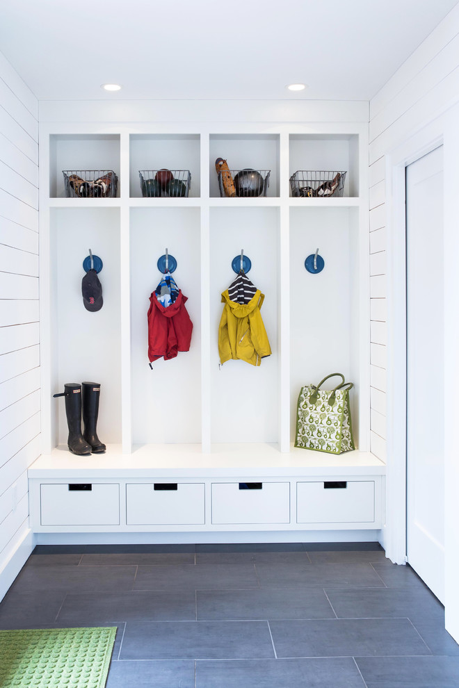 This is an example of a beach style mudroom in Boston with white walls and slate floors.