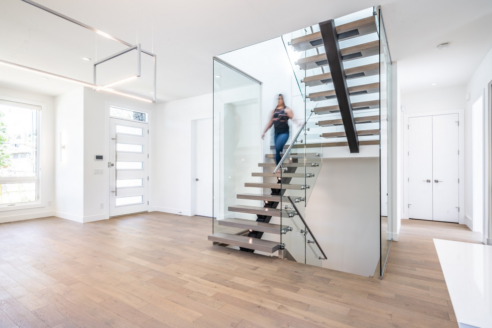 Photo of a mid-sized transitional wood l-shaped staircase in Calgary with open risers and metal railing.