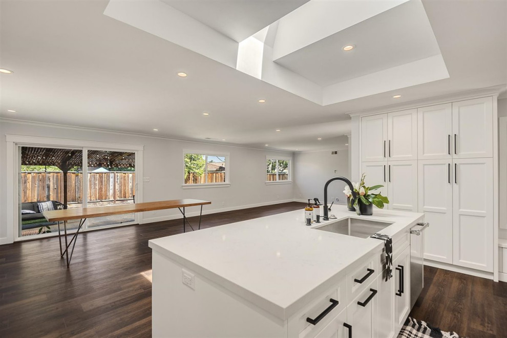 Idéer för att renovera ett mellanstort funkis vit vitt kök, med en undermonterad diskho, skåp i shakerstil, vita skåp, bänkskiva i kvartsit, flerfärgad stänkskydd, stänkskydd i marmor, rostfria vitvaror, vinylgolv, en köksö och brunt golv