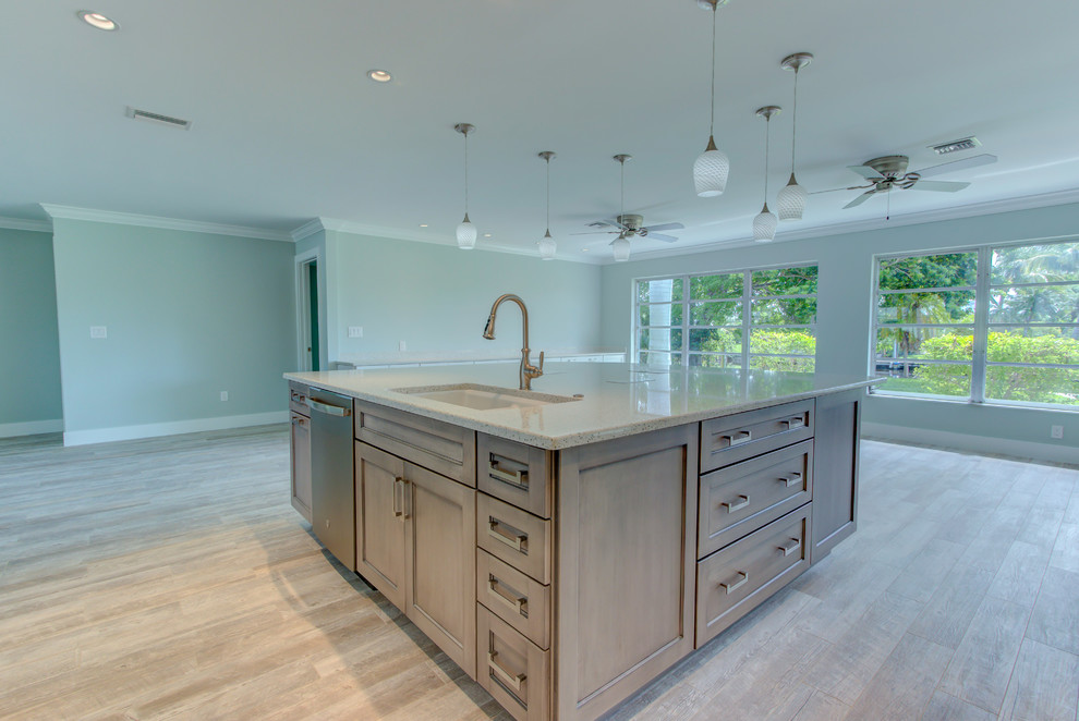 Inspiration for a large transitional l-shaped ceramic tile and gray floor home design remodel with an undermount sink, shaker cabinets, white cabinets, recycled glass countertops, blue backsplash, glass tile backsplash, stainless steel appliances, an island and white countertops