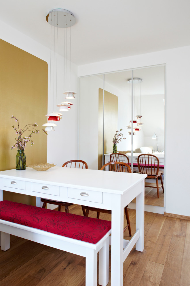 Small contemporary open plan dining in Munich with white walls and light hardwood floors.