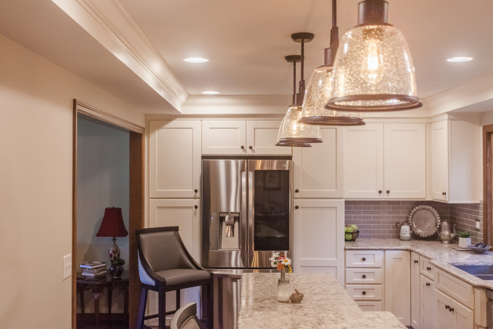 Large transitional single-wall dark wood floor, brown floor and coffered ceiling eat-in kitchen photo in Cincinnati with a double-bowl sink, shaker cabinets, white cabinets, granite countertops, gray backsplash, subway tile backsplash, stainless steel appliances, an island and multicolored countertops