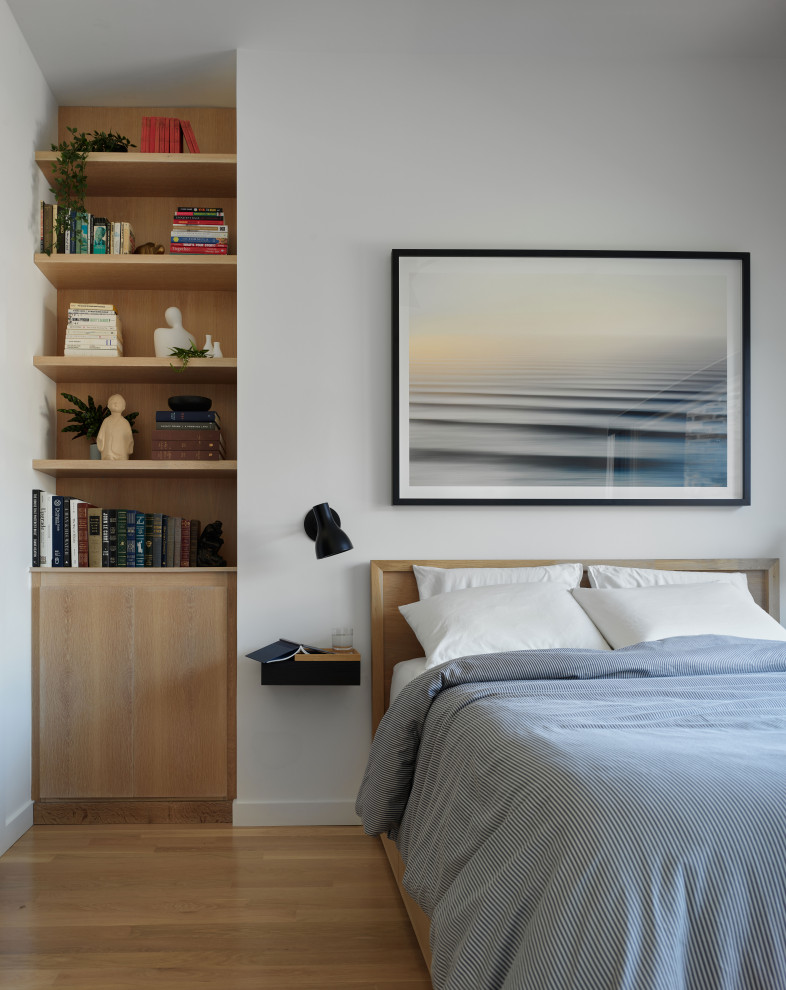 Ejemplo de dormitorio principal contemporáneo de tamaño medio con paredes blancas, suelo de madera en tonos medios y suelo marrón