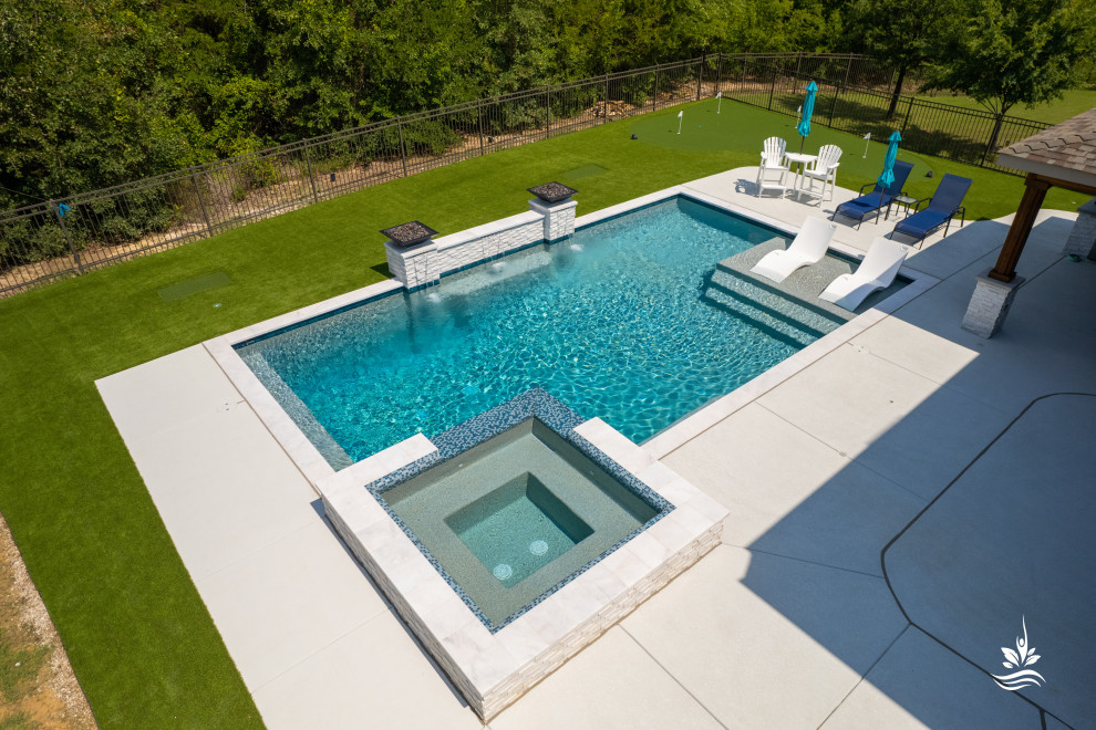 Large modern backyard rectangular natural pool in Dallas with with a pool and decking.