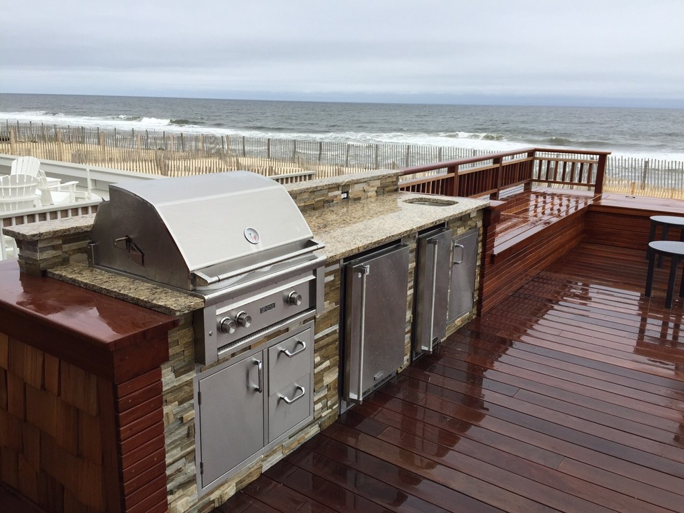 Photo of a large beach style backyard deck in New York with an outdoor kitchen and no cover.