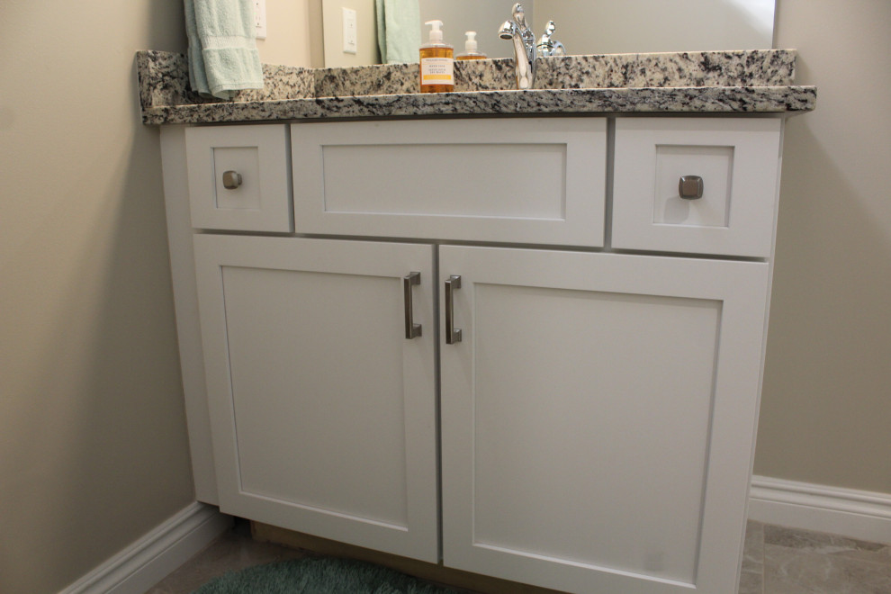 This is an example of a mid-sized transitional bathroom in Detroit with shaker cabinets, medium wood cabinets, granite benchtops, grey benchtops, a single vanity and a built-in vanity.