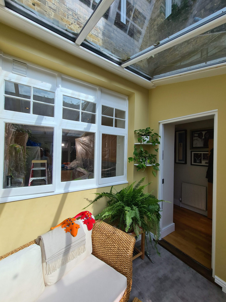 Exempel på en mellanstor klassisk innätad veranda på baksidan av huset, med kakelplattor, takförlängning och räcke i glas