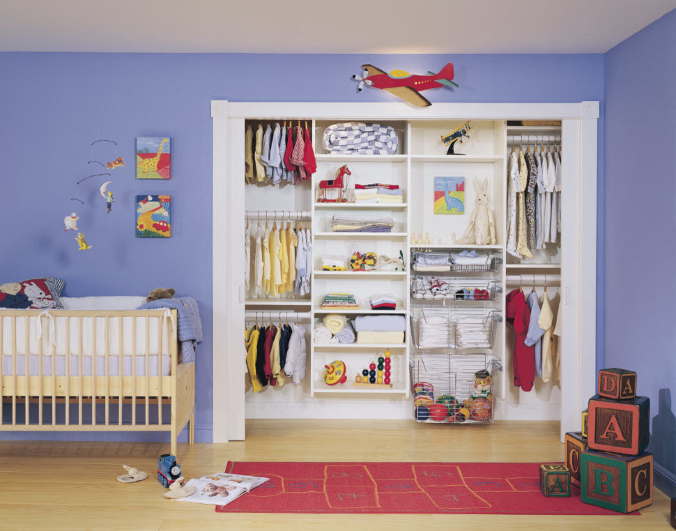 This is an example of a small contemporary gender-neutral kids' room in New York with blue walls and light hardwood floors.