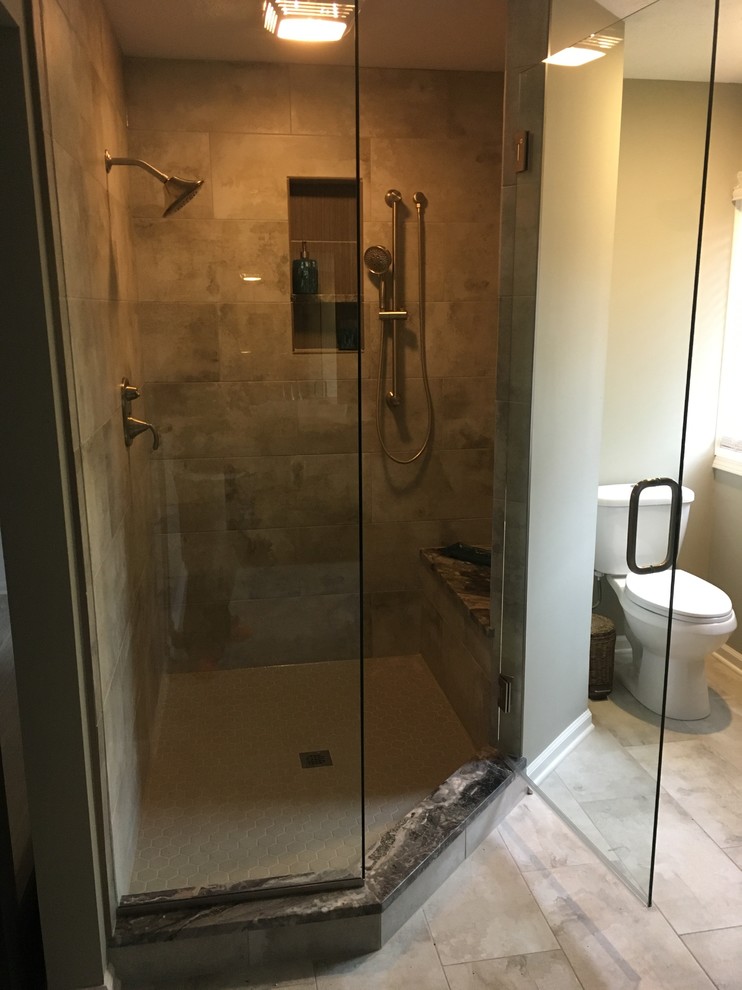 Photo of a large transitional bathroom in Cleveland with a corner shower, beige tile, porcelain tile, porcelain floors and marble benchtops.