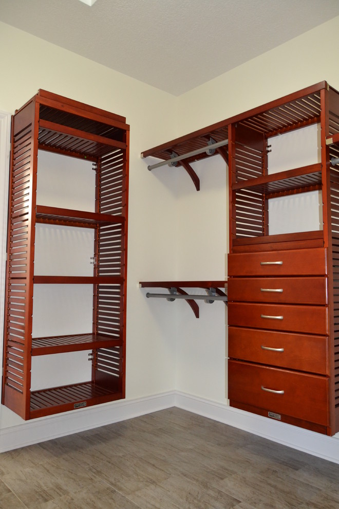Mid-sized arts and crafts gender-neutral walk-in wardrobe in Cleveland with medium wood cabinets and vinyl floors.