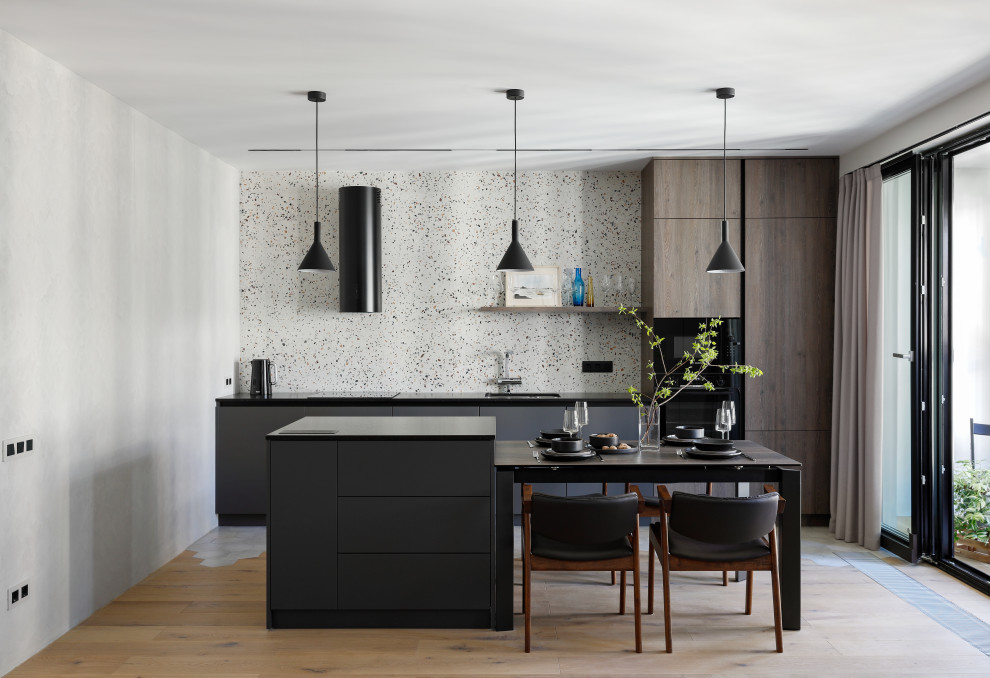 Example of a mid-sized trendy galley light wood floor and beige floor eat-in kitchen design in Saint Petersburg with an undermount sink, flat-panel cabinets, gray cabinets, quartz countertops, multicolored backsplash, limestone backsplash, black appliances, an island and black countertops