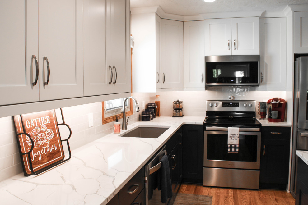 Transitional u-shaped kitchen pantry photo with an undermount sink, shaker cabinets, stainless steel appliances and an island