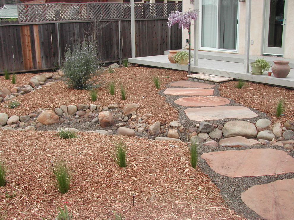 Photo of a mid-sized mediterranean backyard partial sun garden in Los Angeles with natural stone pavers.
