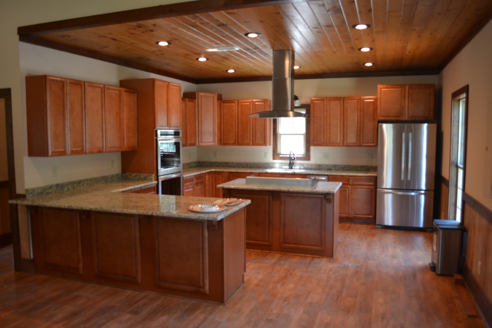 Mid-sized mountain style u-shaped medium tone wood floor kitchen photo in Atlanta with raised-panel cabinets, brown cabinets, granite countertops, stainless steel appliances and an island