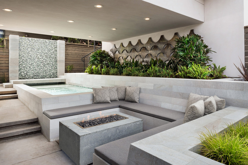 This is an example of a contemporary courtyard patio in San Diego with a water feature and concrete slab.