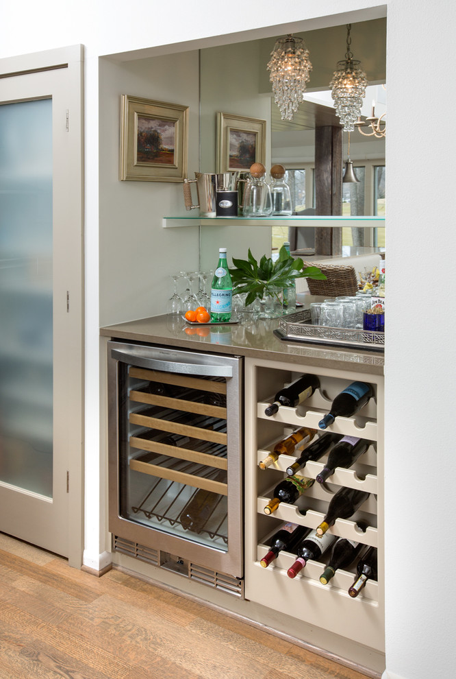Huge transitional galley light wood floor home bar photo in Columbus with an undermount sink, shaker cabinets, beige cabinets, quartzite countertops, beige backsplash, glass tile backsplash, stainless steel appliances and an island