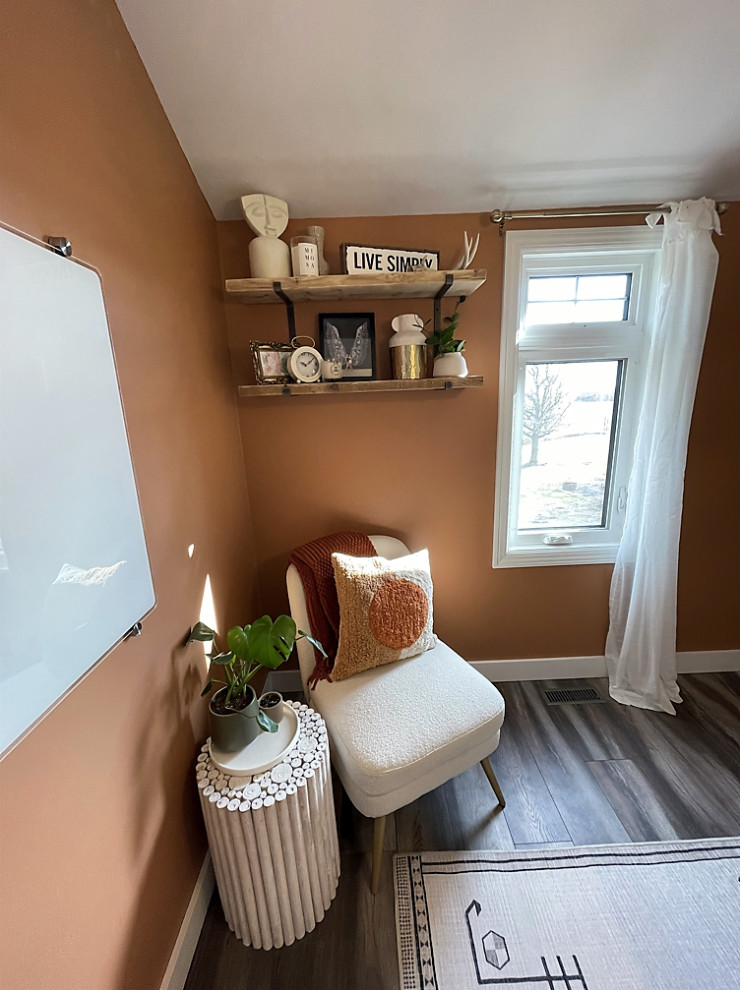 This is an example of a small country home office in Other with orange walls, laminate floors, no fireplace, a freestanding desk, grey floor and wallpaper.
