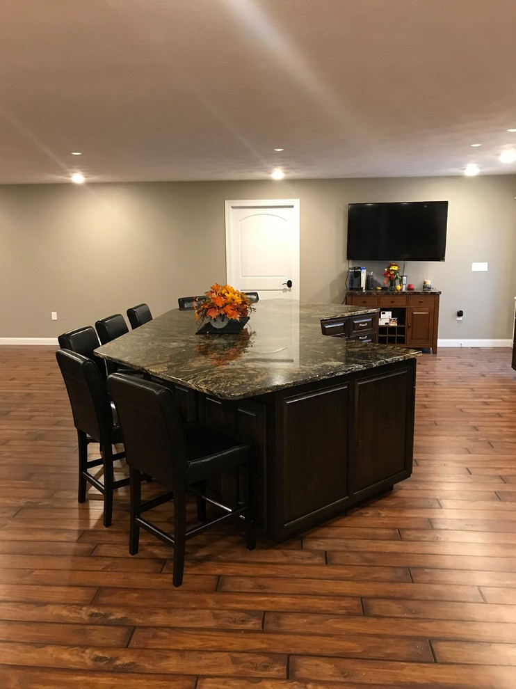 Example of a large classic galley dark wood floor and brown floor open concept kitchen design with raised-panel cabinets, granite countertops, stainless steel appliances, an undermount sink, dark wood cabinets and an island