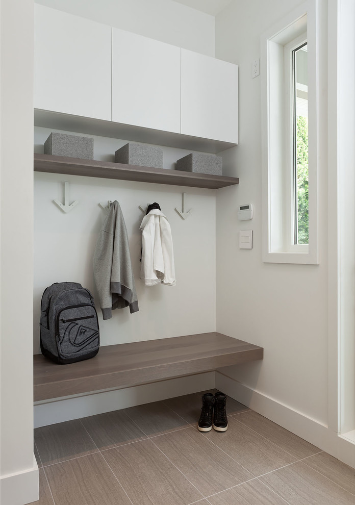 Design ideas for a small scandinavian mudroom in Vancouver with white walls and grey floor.