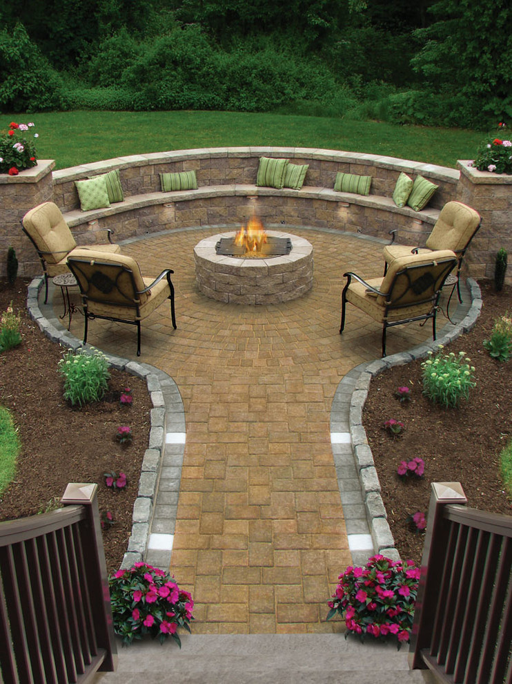 Photo of a mid-sized traditional backyard patio in Other with a fire feature, concrete pavers and no cover.