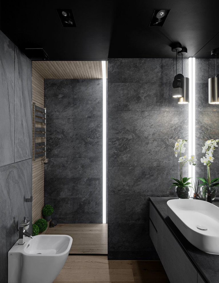 Photo of a contemporary bathroom in Moscow with flat-panel cabinets, grey cabinets, a vessel sink, brown floor and black benchtops.