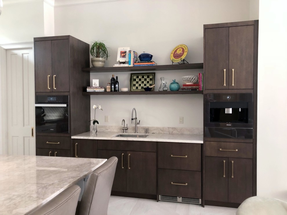 Mid-sized contemporary l-shaped open plan kitchen in New Orleans with a single-bowl sink, flat-panel cabinets, dark wood cabinets, quartzite benchtops, panelled appliances, porcelain floors, with island and grey floor.