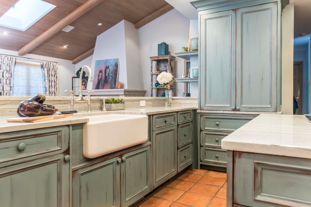 Photo of a country kitchen in Indianapolis with recessed-panel cabinets, distressed cabinets, white splashback, stainless steel appliances and terra-cotta floors.